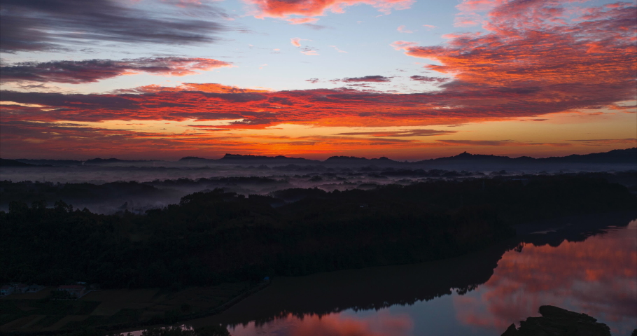amazing beautiful sunrise aerial hyper lapse in the rural China with colorful clouds moving reflection in the river water