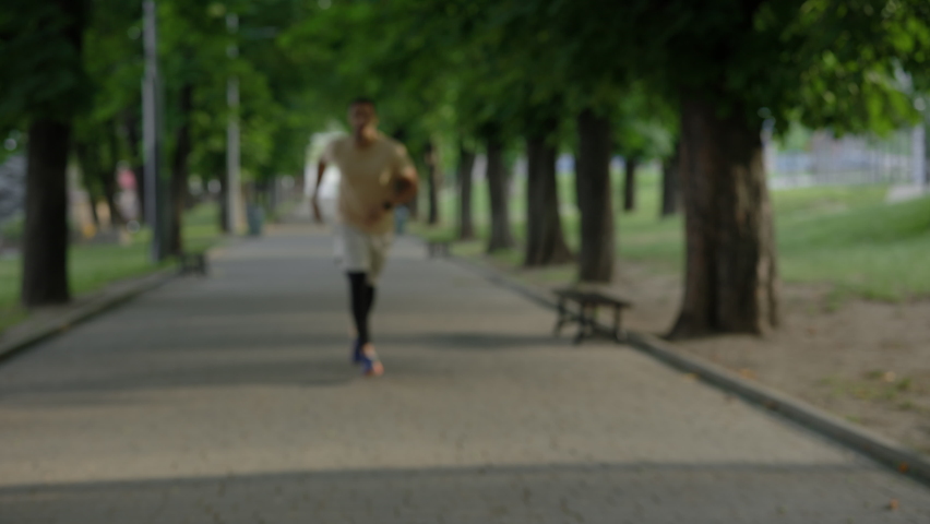 Portrait of the african american runner stopping to take deep breath during the training in the park wearing the smart watch. Blurred background. Sport and healthy lifestyle concept | Shutterstock HD Video #1094878565