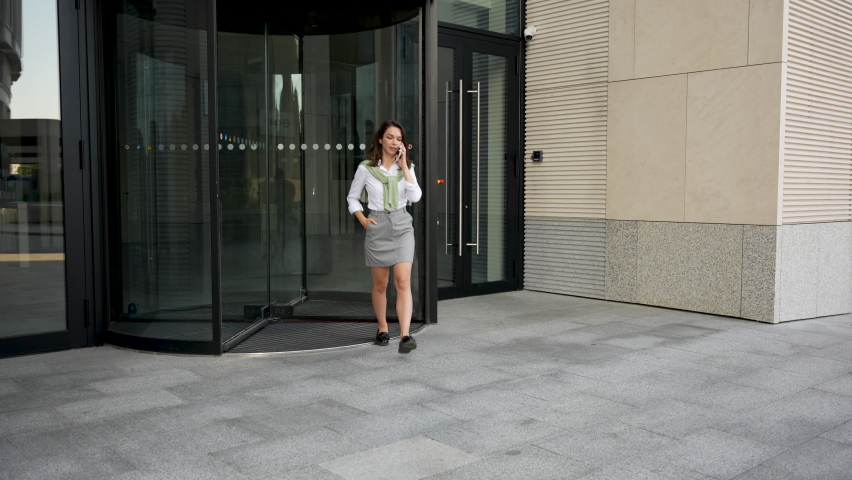 Successful confident businesswoman walking outdoors smiling waving hello greeting. Young woman nice to meet her partners against office building. Royalty-Free Stock Footage #1094882933