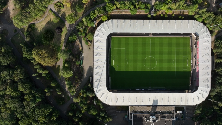Soccer football stadium top down overhead Aerial in forrest park. Green grass landmark landscape architecture structure stands proffesional football club.