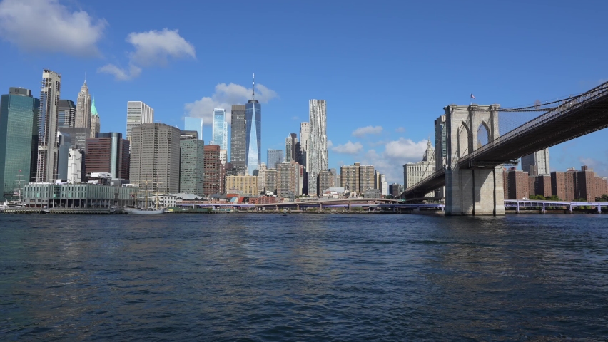 4k video from a boat, view to East River with Manhattan and Brooklyn bridges landmark and other iconic buildings from New York City during a beautiful sunny day. | Shutterstock HD Video #1094893065