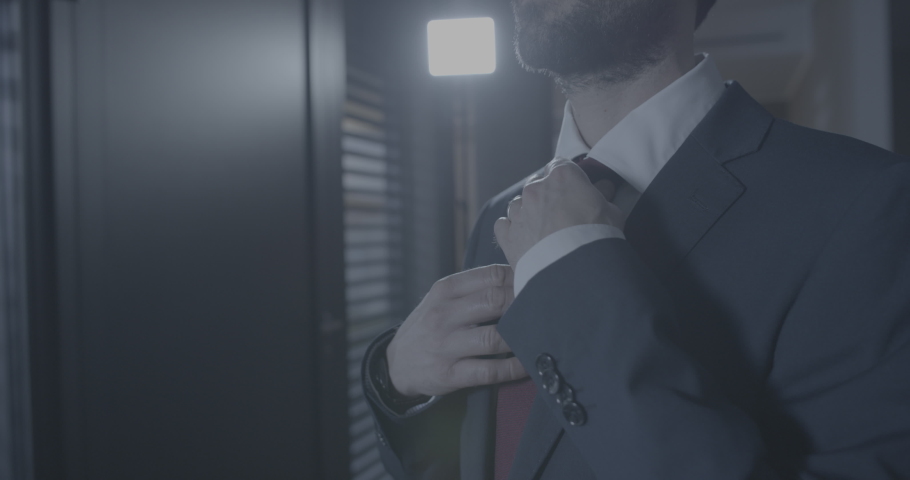 A young man fixing his tie for work, man leaving home for work, dressed up man wearing a suit and a tie | Shutterstock HD Video #1094894487