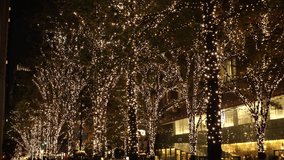 TOKYO, JAPAN - NOVEMBER 2021 : Christmas illumination, led light up at Marunouchi area. Scenery of downtown city and street at night. Japanese winter and Christmas season concept video.