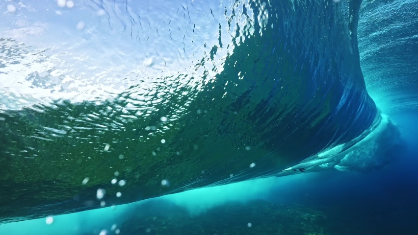 Underwater shot of blue barreling wave with silhouette of surfer in the barrel riding in slow motion. Tahiti famous surf destination for professional surfers, French Polynesia.  Royalty-Free Stock Footage #1094905823