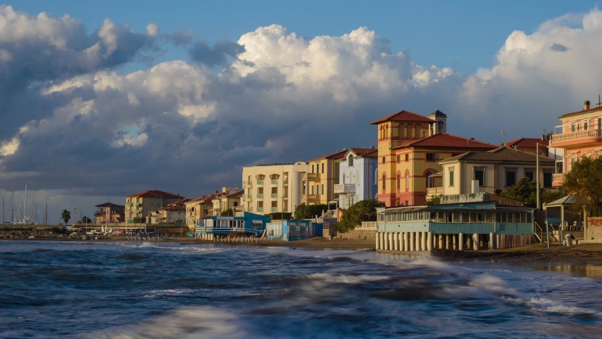 Seascape, sunset over the Tuscan town of San Vincenzo, Italy. Time lapse with clouds, sand and waves