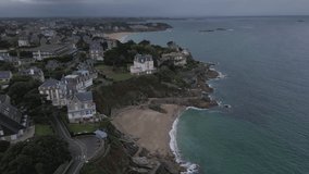 Old English style houses on rocky and jagged coast, Dinard in Brittany. Aerial forward