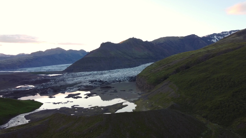 Sunset Glacier Shot in Iceland Ringroad, drone moving forward reflection of mountain in glacial lake.