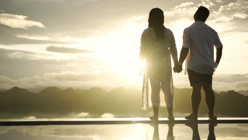 couple enjoying sunrise holding hands romantically