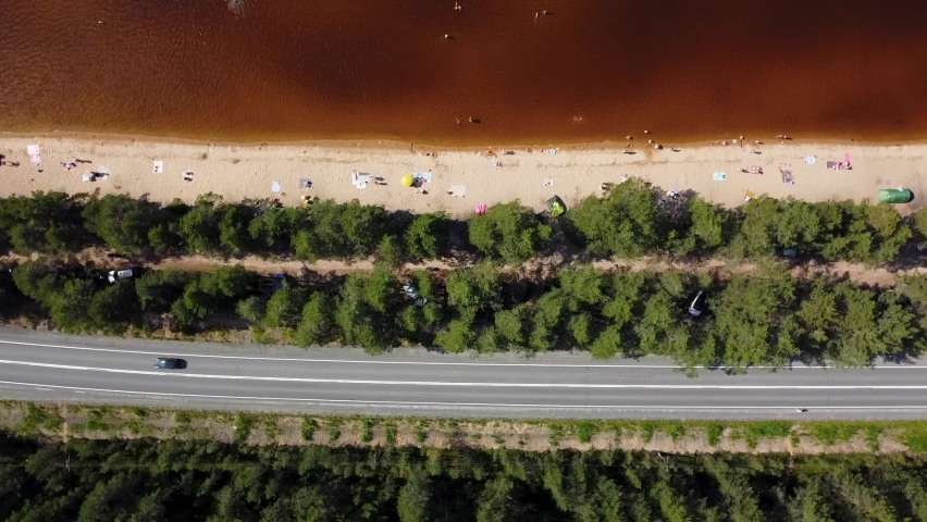Syamozero, Russia 07.01.2022 Aerial top view. Spinning over lake beach in pine forest with swimming people | Shutterstock HD Video #1094925905
