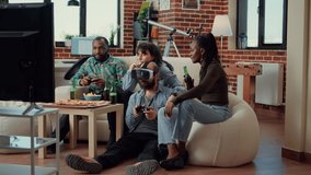 Happy man using vr glasses to play video games on console, having fun with friends at gathering. Playing online gaming competition with virtual reality headset on television, group hangout.
