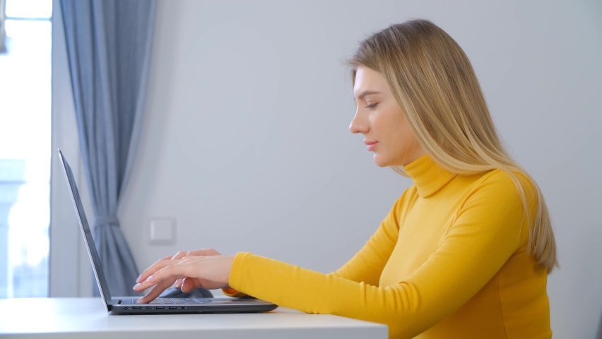 Young woman typing text on laptop keyboard. Focused white female person working on notebook computer at home | Shutterstock HD Video #1094928735