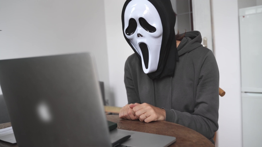 Anonymus person with ghost mask working with laptop. Halloween work concept | Shutterstock HD Video #1094929305