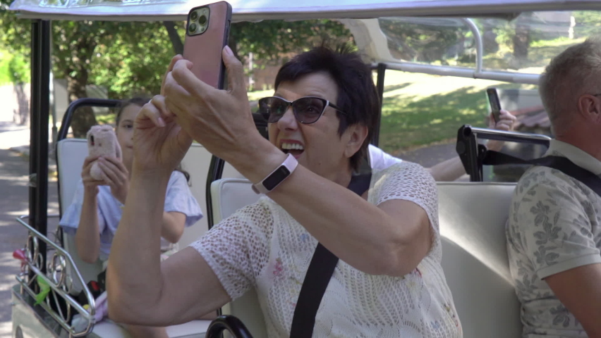 A group of tourists driving through the city center in tuk-tuk electric car. Travelers enjoying a ride on environmentally friendly transport in the old town