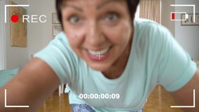 Mature woman recording trendy dance moves for social media account at home. Woman 50-60 years old shooting short video on smartphone. Concept social media, stories, and trendy dance. Sequence