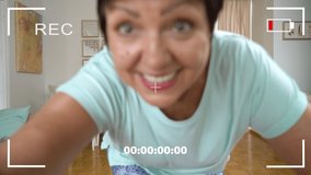 PHONE CAMERA POV. Mature woman recording trendy dance moves for social media account shooting short video on smartphone at home. Concept social media, stories, and trendy dance.