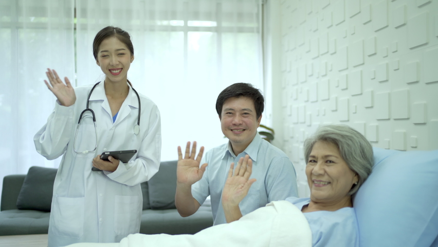 Happy specialist doctors and senior elder woman patient waving a hands to camera in recovery ward in hospital. Cheerful medical staffs and patient waving a hands to camera. | Shutterstock HD Video #1094932221