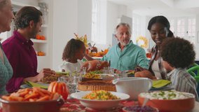 Multi-generation family joining hands to say prayer before enjoying Thanksgiving meal together - shot in slow motion - Powered by Shutterstock - Get 15% off with code: PIKWIZARD15