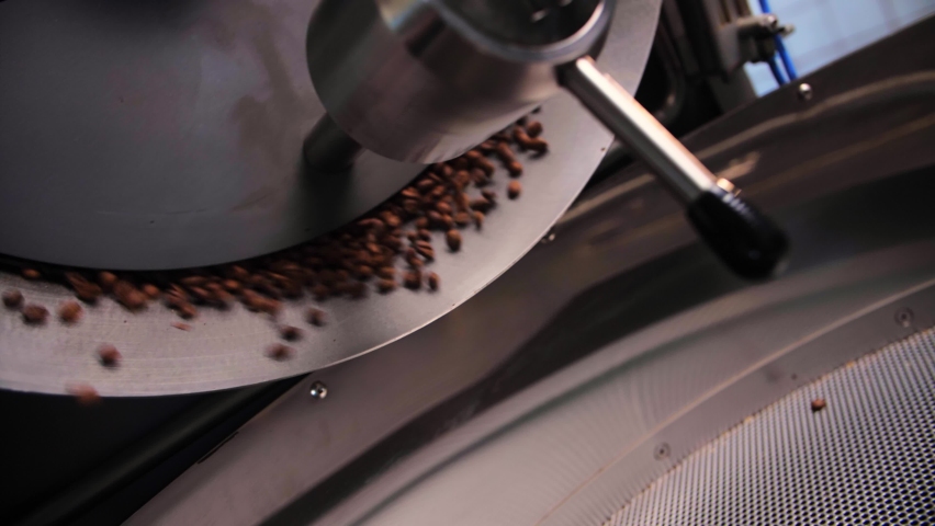 Coffee roaster machine mixing aroma beans.Preparation fresh aroma caffeine on manufacturing warehouse.Close-up Make ready coffee in large roaster falling beans. High quality 4k footage Royalty-Free Stock Footage #1094935651