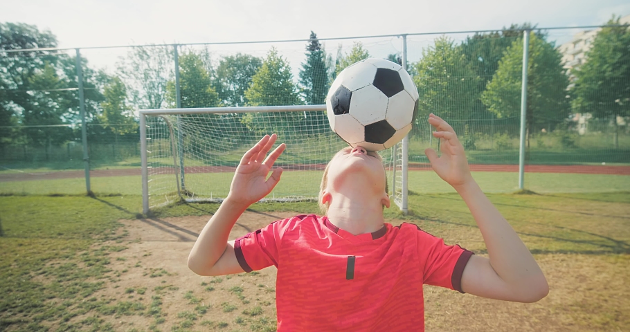 Boy football players in dynamic action have fun playing Soccer in the grass, summer sunny day under sunlight.	 | Shutterstock HD Video #1094936371