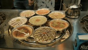 Few plates of a personal Knafeh dishes, rotating above a slow burning stove, creating a magnificent hi-tech view, in the Israeli\Arab market of Jerusalem. an NTSC video clip, Israel.