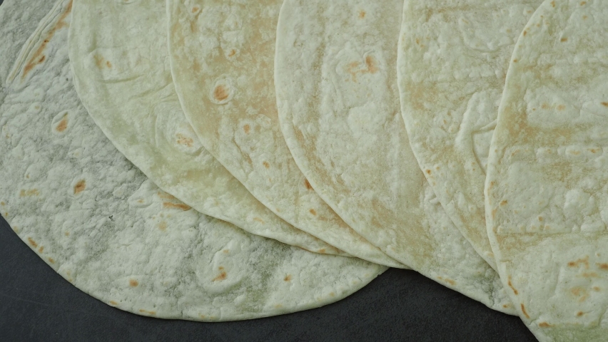 Corn tortillas on black background. Unleavened bread. Mexican tortillas
