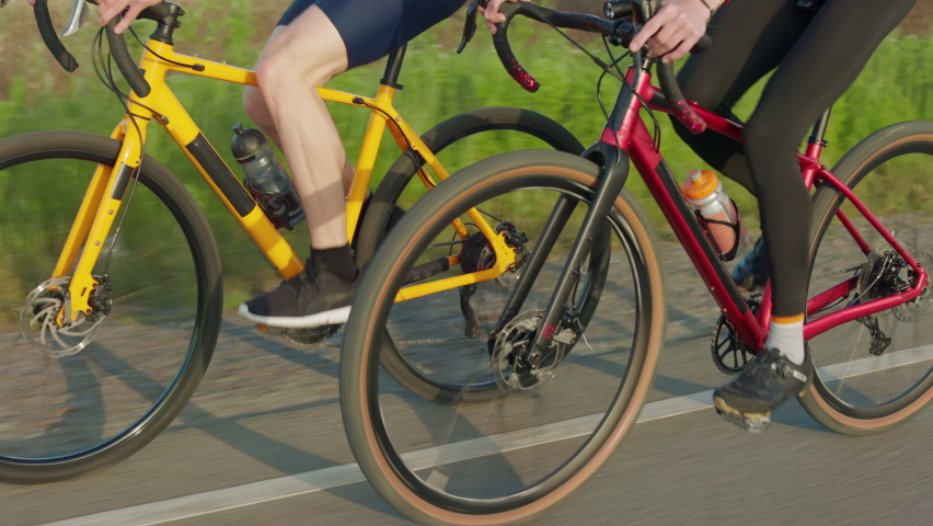 Close up of two male cyclists in sport clothes riding bikes together on fresh air. Happy young friends spending leisure time for outdoors activity. | Shutterstock HD Video #1094937105