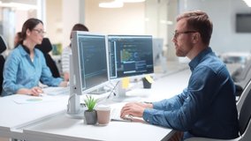 Young Caucasian IT programer working on desktop computers in data center control room. Professional man worker writing on sophisticated programming code language in modern office. Internet technology - Powered by Shutterstock - Get 15% off with code: PIKWIZARD15