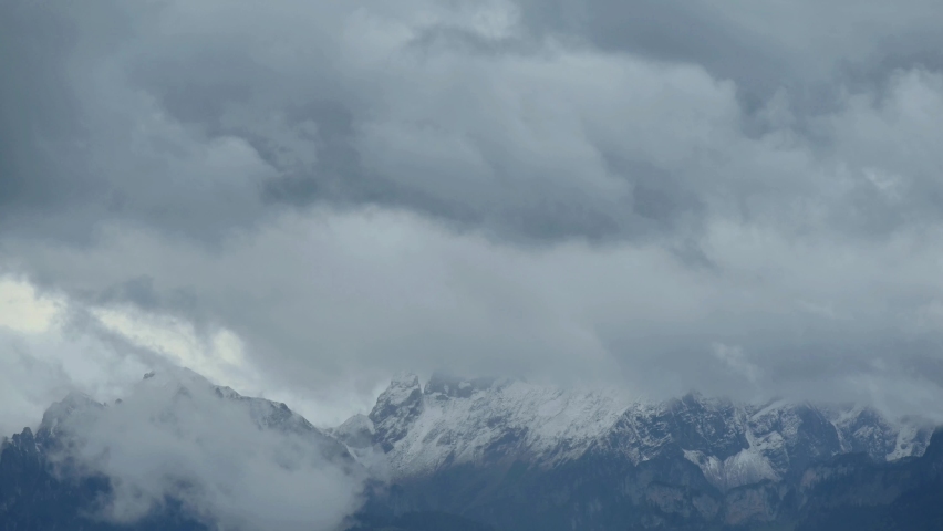 Landscape of mountain, sky and clouds. Real time of dark clouds and mist over snowcapped mountains. 