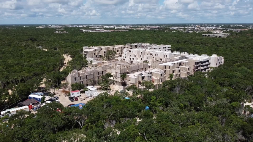 Aerial of a construction building site in Tulum Mexico surrounded by jungle | Shutterstock HD Video #1094939935