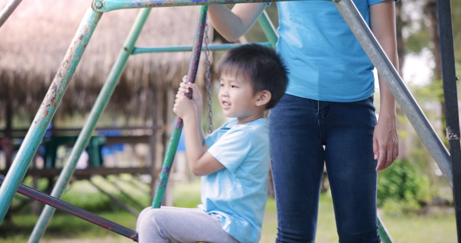 4k slow motion of 2 asian people, mom and child, kid or little boy to play swing set in playground, park, outdoor or garden. Mother to take care or support. Concept for activity, fun, happy, relaxing. | Shutterstock HD Video #1094942007