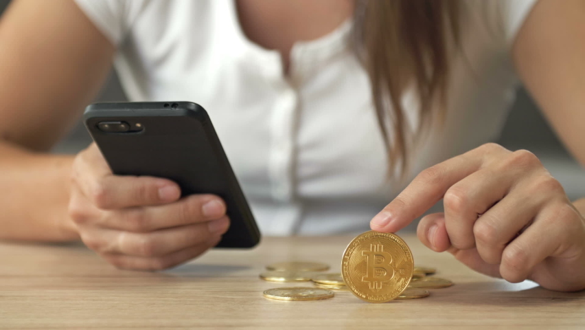Bitcoin coin and calculator in female hands. | Shutterstock HD Video #1094942261