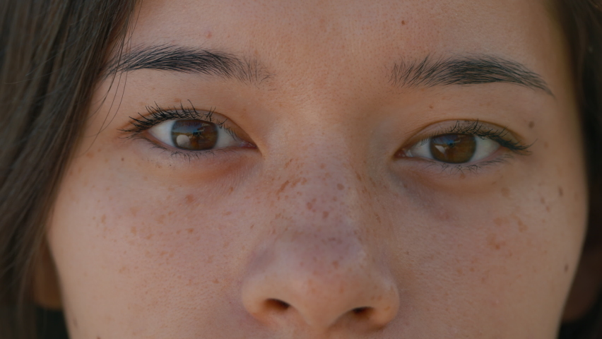 Close up of womans face, female opening her beautiful brown eyes, attractive asian woman. Natural beauty with freckles. Gorgeous woman with long eyelashes and attractive appearance. Slow motion Royalty-Free Stock Footage #1094942443