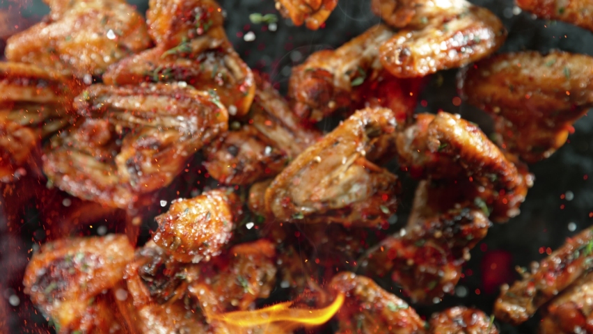 Super Slow Motion Shot of Grilled Spicy Chicken Wings Flying Towards Camera at 1000fps. Royalty-Free Stock Footage #1094942555
