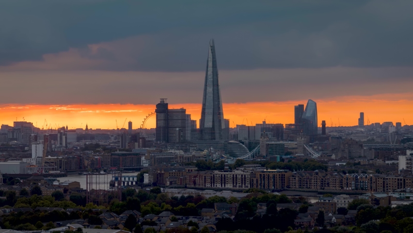 Sunset time lapse view of the skyline of London, United Kingdom, with Tower Bridge and the modern office skyscrapers along the Thames river