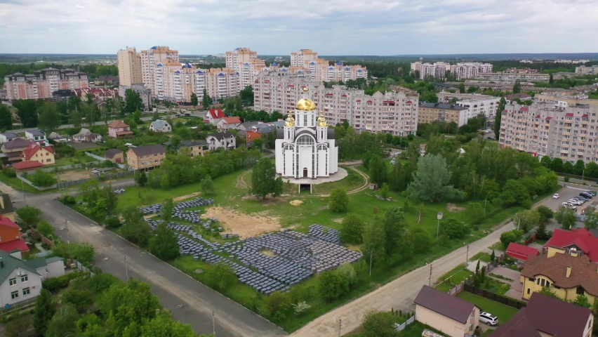 UKRAINE - CIRCA 2022 - aerial of the Church of St. Andrew Pervozvannoho All Saints in Bucha, Ukraine where dozens of unmarked graves were unearthed. | Shutterstock HD Video #1094950775