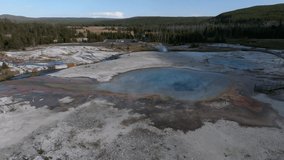Aerial video of deep green orange geyser pool in the Yellowstone National Park. Scenic view over colorful Norris Geyser Basin in Yellowstone National Park