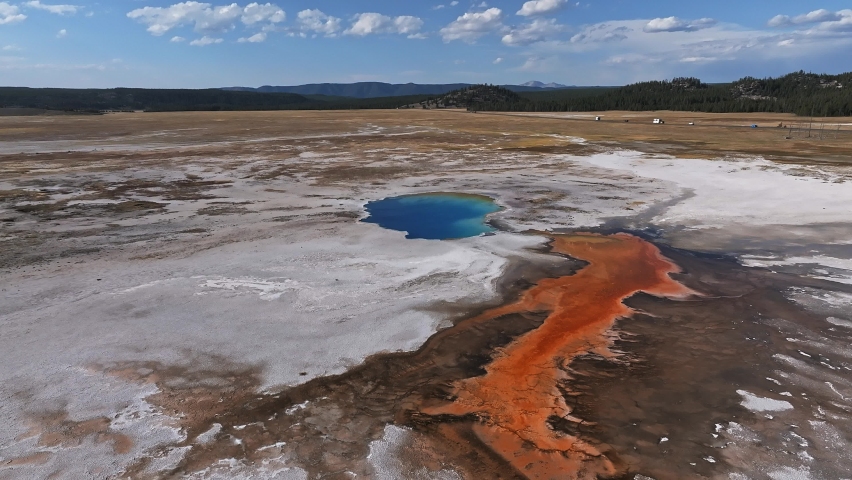 Aerial video of deep green orange geyser pool in the Yellowstone National Park. Scenic view over colorful Norris Geyser Basin in Yellowstone National Park