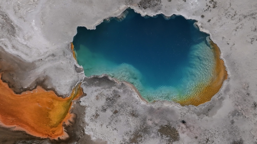 Aerial video of deep green orange geyser pool in the Yellowstone National Park. Scenic view over colorful Norris Geyser Basin in Yellowstone National Park