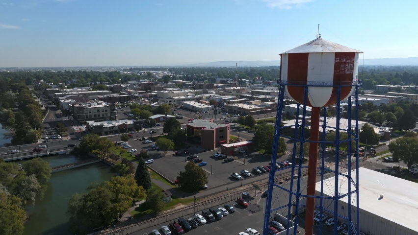 Aerial video of the water tower and waterfall in the city of Idaho Falls, ID USA. Large straight waterfall across the city in Idaho Falls.