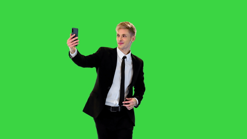 Young cool businessman dressed in formal suit walking and taking selfie on a Green Screen, Chroma Key. | Shutterstock HD Video #1094954817