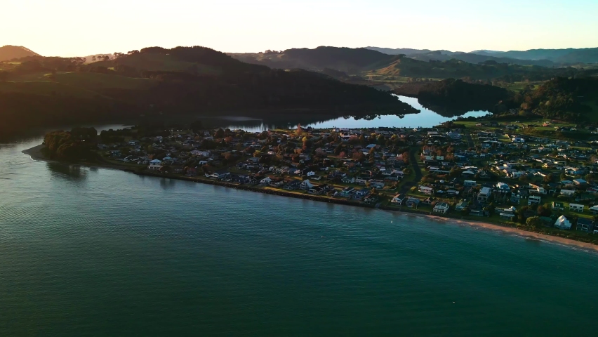 Sunrise waves rolling into the beach with mountains in the background 