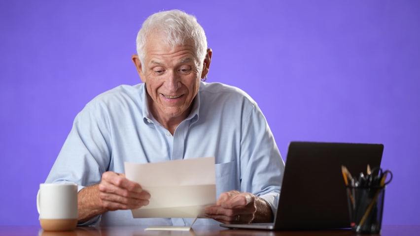 Excited male elderly man opening mail letter reading good news celebrating success. Happy receiving loan approval, salary bonus, get promoted concept isolated on solid purple background | Shutterstock HD Video #1094958575