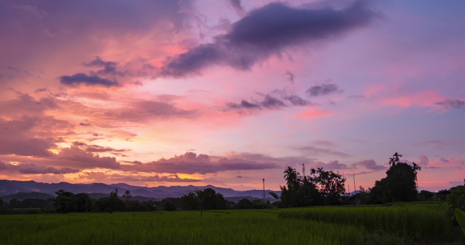 4K Time lapse of Majestic dusk or dawn landscape Amazing light of nature cloudscape sky and Clouds moving away rolling colorful above the paddy fields. Nature environment background | Shutterstock HD Video #1094958873