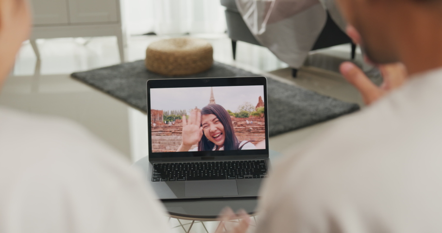 Happy young Asian couple sit on couch smiling looking at laptop screen talk video call with friends at home on holiday. Smile young husband and wife webcam conversation using internet connection. | Shutterstock HD Video #1094961425