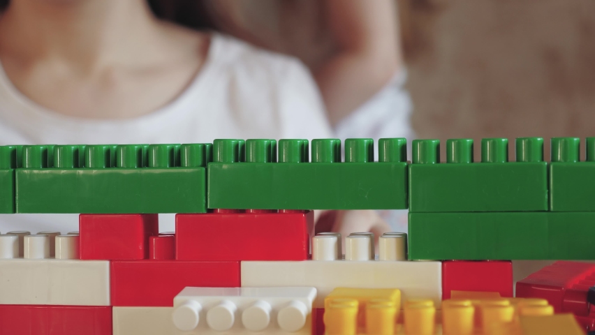 Little child plays constructor with his mother. happy family. kid builds multi-colored lego tower. psychologist engaged child play activity. center preschool education. kid child kindergarten teacher. | Shutterstock HD Video #1094964335