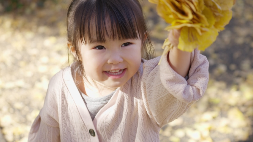 Asian child playing with fallen leaves | Shutterstock HD Video #1094965245