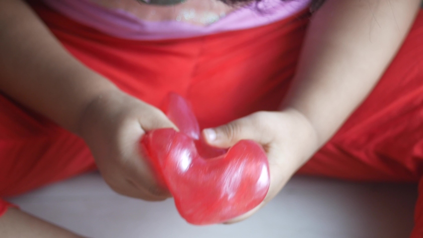 child Hand holding pink color slime 