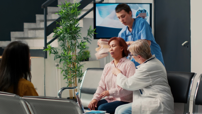 Diverse medical staff helping woman with cervical collar, removing neck brace after injury rehabilitation. Healing fracture after accident and doing healthcare checkup with nurse and doctor. | Shutterstock HD Video #1094968413