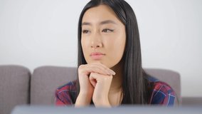 Portrait of asian girl thinking about future. Young Vietnamese woman looking away in thought. Download stock clip of cute southeast asian female person pondering. BIPOC person lifestyle video