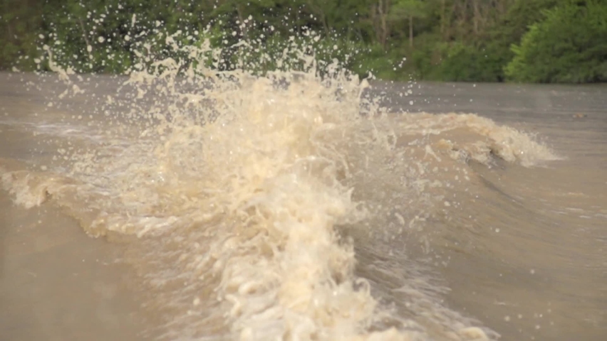 Slow motion waves behind a boat on a murky river in Colombia | Shutterstock HD Video #1094976225